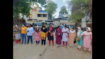 Women block the road for garbage collection trucks, seen behind them, from dumping garbage in open ground which has been spreading foul stench in the area in New Panvel (Bachchan KumarHT PHOTO) Women block the road for garbage collection trucks, seen behind them, from dumping garbage in open ground which has been spreading foul stench in the area in New Panvel (Bachchan KumarHT PHOTO)