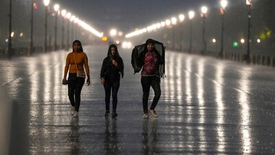 People walk on a road amid rains, in New Delhi, Tuesday, May 30, 2023. (PTI)