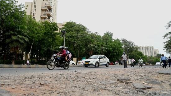 A potholed stretch on the Old Delhi-Gurgaon Road near Gurgaon One Apartments. (Parveen Kumar/HT Photo)