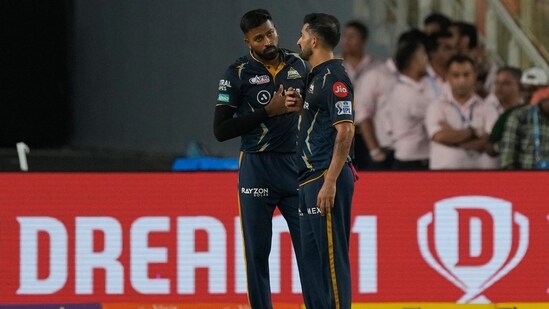 Gujarat Titans' Mohit Sharma, right, listens to captain Hardik Pandya before bowling his fifth delivery (AP)