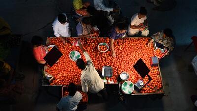 Customers buy vegetables at a night market in Hyderabad. (AFP) Customers buy vegetables at a night market in Hyderabad. (AFP)