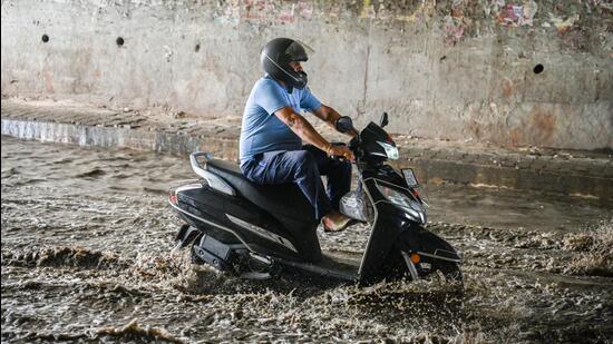 A commuter wades through a waterlogged stretch at Pandav Nagar underpass following heavy rains in New Delhi. (Raj K Raj/HT)