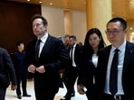 Tesla chief executive officer Elon Musk walks next to Tesla's Senior Vice President Tom Zhu and Vice President Grace Tao as he leaves a hotel in Beijing, China