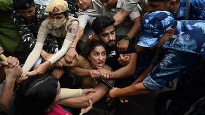 Indian wrestlers Vinesh Phogat (C) with others are detained by the police while attempting to march to India's new parliament. (AFP) Indian wrestlers Vinesh Phogat (C) with others are detained by the police while attempting to march to India's new parliament. (AFP)