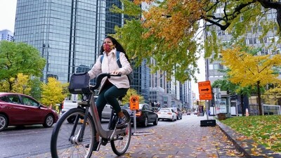 A woman rides a bike in downtown Montreal, on Tuesday, Oct. 20, 2020, (AP)