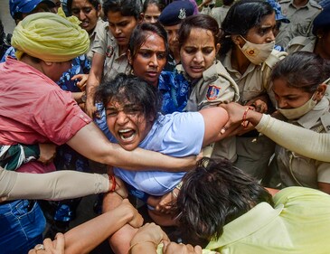 Security personnel detain wrestler Sakshi Malik during wrestlers' protest march towards new Parliament building, in New Delhi on May 28 (PTI)