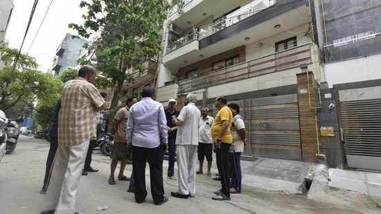 Locals stand outside the house where the mother-daughter duo were murdered in Delhi’s Krishna Nagar on late Wednesday night, on Thursday. (Sonu Mehta/HT)