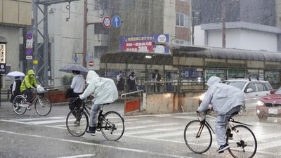 People make their way in a strong rain in Kochi, southern Japan. (AP) People make their way in a strong rain in Kochi, southern Japan. (AP)