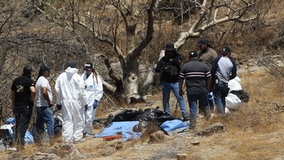 Forensic experts work with several bags of human remains extracted from the bottom of a ravine by a helicopter, which were abandoned at the Mirador Escondido community in Zapopan, Jalisco state, Mexico on May 31. (AFP) Forensic experts work with several bags of human remains extracted from the bottom of a ravine by a helicopter, which were abandoned at the Mirador Escondido community in Zapopan, Jalisco state, Mexico on May 31. (AFP)