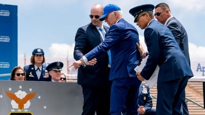 Biden points to sandbags after falling on stage during the 2023 Air Force Academy graduation ceremony. (AP) Biden points to sandbags after falling on stage during the 2023 Air Force Academy graduation ceremony. (AP)