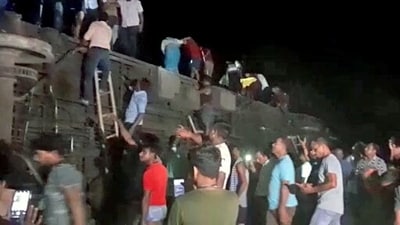 Locals gather after the Coromandel Express derails after hitting a goods train near Bahanaga station in Balasore on Friday. (ANI Photo) (ANI) Locals gather after the Coromandel Express derails after hitting a goods train near Bahanaga station in Balasore on Friday. (ANI Photo) (ANI)