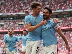 Manchester City's English defender John Stones (L) congratulates Manchester City's German midfielder Ilkay Gundogan after the second goal 