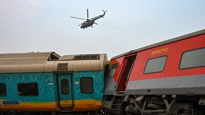 An army helicopter flies above the carriage wreckage of a three-train collision near Balasore, Odisha, on June 3. (AFP) An army helicopter flies above the carriage wreckage of a three-train collision near Balasore, Odisha, on June 3. (AFP)