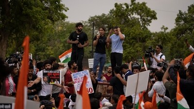 Indian wrestlers, from left, Bajrang Punia, Vinesh Phogat, and Sakshi Malik stand on a police barricade during a protest march. (AP) Indian wrestlers, from left, Bajrang Punia, Vinesh Phogat, and Sakshi Malik stand on a police barricade during a protest march. (AP)