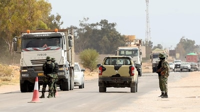 Libyan security forces man a check point in the surrounding area during the trial of jihadists accused of being members of the Islamic State (IS) group, in the northwestern city of Misrata. (AFP)