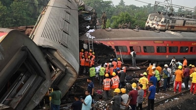 Rescue workers gather around damaged carriages at the accident site of a three-train collision near Balasore, about 200 km (125 miles) from the state capital Bhubaneswar in Odisha on Saturday. (AFP) Rescue workers gather around damaged carriages at the accident site of a three-train collision near Balasore, about 200 km (125 miles) from the state capital Bhubaneswar in Odisha on Saturday. (AFP)