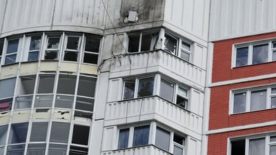 Russia-Ukraine War: A woman looks out of a window of a damaged multi-storey apartment block following a reported drone attack in Moscow. (Reuters)