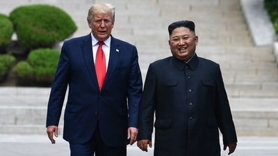 North Korean leader Kim Jong Un walks with former US President Trump north of the military demarcation line that divides North and South Korea, in the Joint Security Area of Panmunjom in the Demilitarized Zone. (AFP)