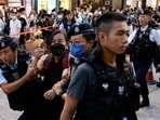 Police detain a woman with paper flowers in downtown on the 34th anniversary of the 1989 Beijing's Tiananmen Square crackdown, near where the candlelight vigil is usually held, in Hong Kong, China on Sunday. 