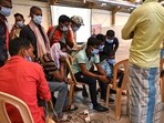 Victims' family members look at photographs to identify bodies at a business park used as temporary mortuary for the dead recovered from the carriage wreckage of a three-train collision near Balasore of Odisha, on Sunday. 