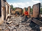 Firefighters work among the ruins of a house, which was hit by Azeri shelling during border clashes. 