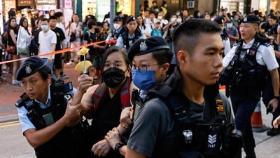 Police detain a woman with paper flowers in downtown on the 34th anniversary of the 1989 Beijing's Tiananmen Square crackdown, near where the candlelight vigil is usually held, in Hong Kong, China on Sunday. (REUTERS)