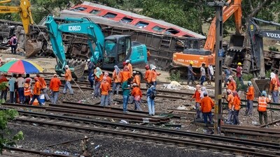 Heavy machinery remove damaged coaches from the railway tracks at the site of a train collision following the accident in Balasore district in the eastern state of Odisha on Sunday. (REUTERS)
