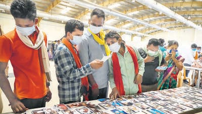 Relatives identify photos of passengers, displayed by railway authorities, at a camp in Odisha’s Balasore on Sunday. (PTI) Relatives identify photos of passengers, displayed by railway authorities, at a camp in Odisha’s Balasore on Sunday. (PTI)