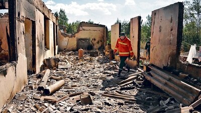 Firefighters work among the ruins of a house, which was hit by Azeri shelling during border clashes. (AFP)