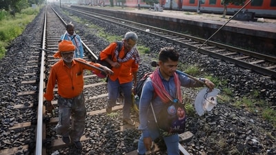 Workers walk on a rail track as a train arrives at Bahanaga Bazar railway station, near the site of the train collision. (REUTERS)
