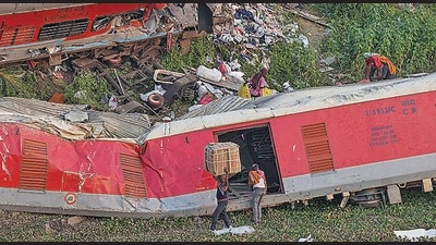 Porters carry goods collected from the mangled coaches at the triple train mishap site where over 270 people died and more than 1000 injured, near Bahanaga Bazar in Balasore district, Monday. (PTI) Porters carry goods collected from the mangled coaches at the triple train mishap site where over 270 people died and more than 1000 injured, near Bahanaga Bazar in Balasore district, Monday. (PTI)