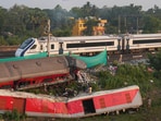 Vande Bharat Express passes by the triple train mishap site where in the foreground derailed coaches still lay bare, near Bahanaga Bazar in Balasore district, Monday.