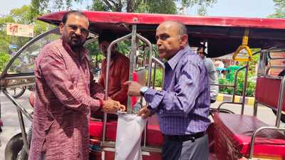 An e-rickshaw driver in Prayagraj being given a jute bag to collecting waste from passengers (HT) An e-rickshaw driver in Prayagraj being given a jute bag to collecting waste from passengers (HT)