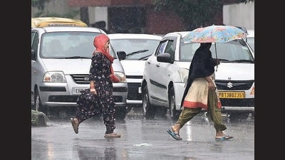 Pedestrians caught in the rain at the Sector 33/45 dividing road in Chandigarh. (Keshav Singh/HT)