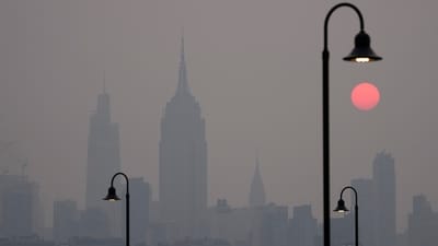 The sun rises over a hazy New York skyline as seen from Jersey City, New Jersey on June 7. Intense Canadian wildfires are blanketing the northeastern US in a dystopian haze, turning the air acrid, the sky yellowish gray, and prompting warnings for vulnerable populations to stay inside, reported AP. (Seth Wenig / AP)