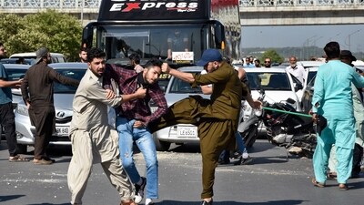 Plainclothes police officers beat a supporter of Pakistan's former Prime Minister Imran Khan during a protest to condemn the arrest of their leader in Peshawar, Pakistan on May 9. (AP)