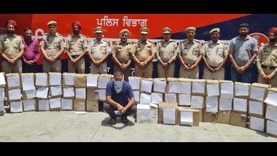 The police with the accused and the seized liquor cartons.