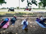 (FILES) Men rest beneath a tree during a hot summer day (FILES) Men rest beneath a tree during a hot summer day