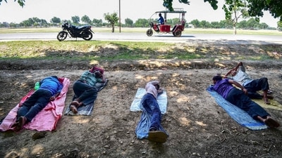 (FILES) Men rest beneath a tree during a hot summer day (AFP)