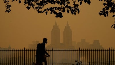 People walk in Central Park as smoke from wildfires in Canada cause hazy conditions in New York City on June 7, 2023. Smoke from Canada's wildfires has engulfed the Northeast and Mid-Atlantic regions of the US, raising concerns over the harms of persistent poor air quality. (AFP)