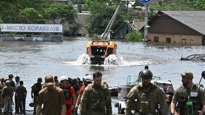 Rescuers ride an all-terrain vehicle during an evacuation from a flooded area in Kherson. (AFP) Rescuers ride an all-terrain vehicle during an evacuation from a flooded area in Kherson. (AFP)