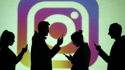 FILE PHOTO: Silhouettes of mobile users are seen next to a screen projection of Instagram logo in this picture illustration taken March 28, 2018. (REUTERS)