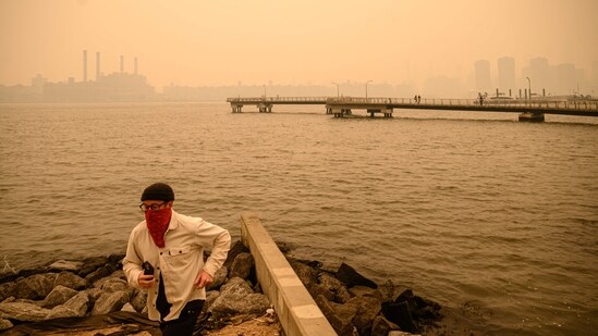 A passenger wearing a face mask rides the Staten Island Ferry past the Statue of Liberty.(AFP)