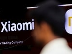 A man walks past a logo of Xiaomi, a Chinese manufacturer of consumer electronics, outside a shop in Mumbai,