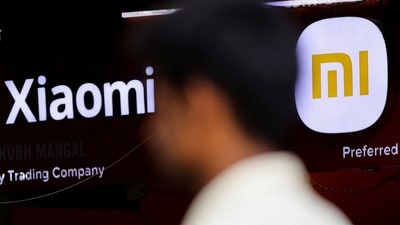 A man walks past a logo of Xiaomi, a Chinese manufacturer of consumer electronics, outside a shop in Mumbai, (REUTERS)
