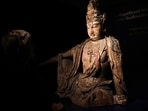 Head of Chinese Art Caroline Schulten at Bonhams auction house looks at a rare Buddha statue, believed to be from the 12th century in China, before its auction in Paris, 