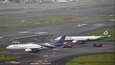This aerial photo shows the airplanes of Thai Airways International, left, and Eva Airways, right, sit close on a runway, after the two passenger planes accidentally hit each other at Haneda airport in Tokyo on Saturday. (AP)