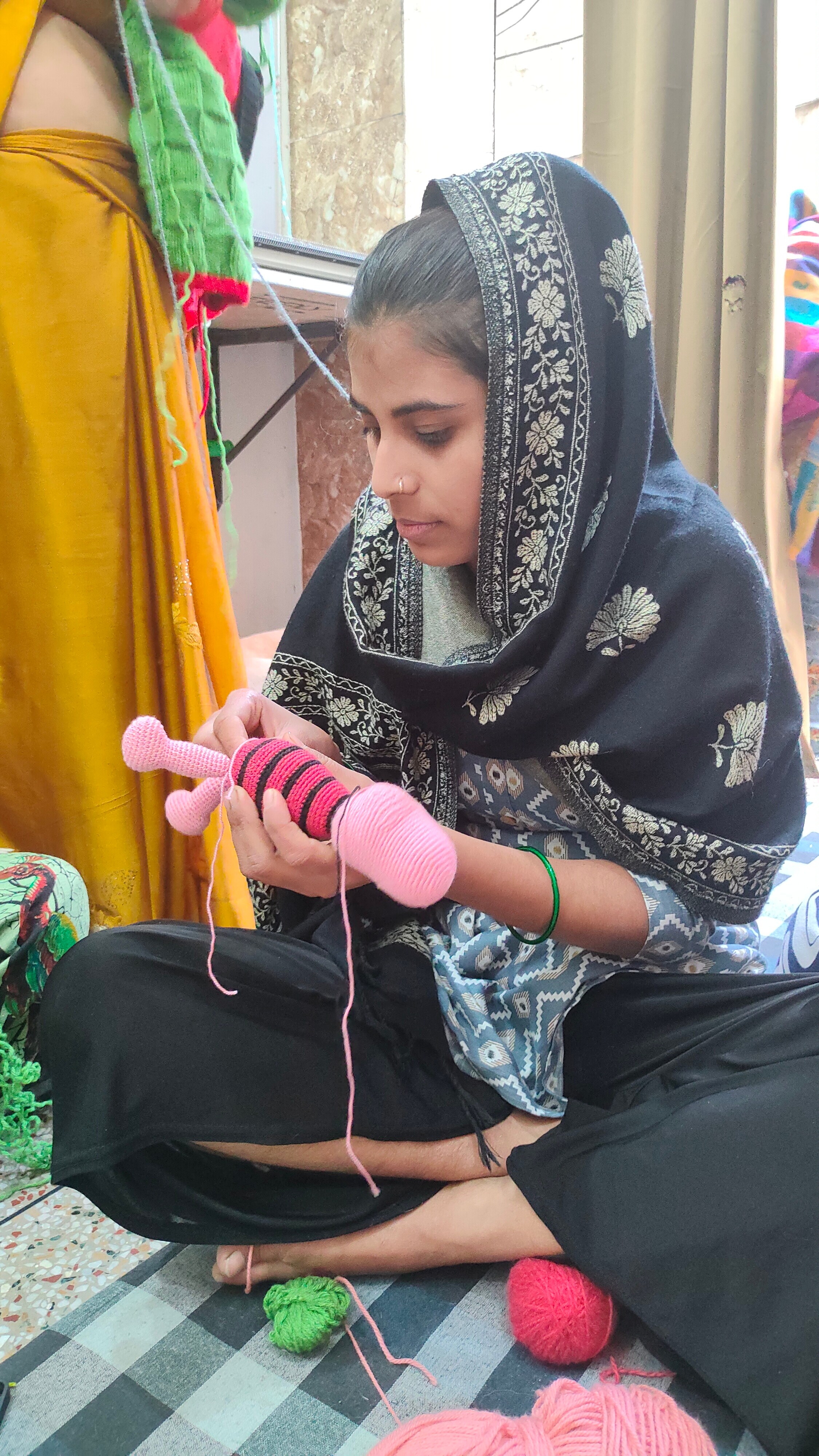 A woman from the Nithari village at Sakha Ek Pehel makes crochet dolls of cartoon character and eminent personalities.