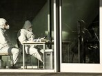 Covid In China: Security guards wearing personal protective equipment (PPE) amid the Covid-19 pandemic sit at an entrance of a building in Beijing.