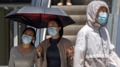 People walk at a shopping and office complex in Beijing. (AP)